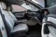 Modern car interior with sleek design, showing front seats, dashboard, and steering wheel, featuring light upholstery and minimalistic controls.