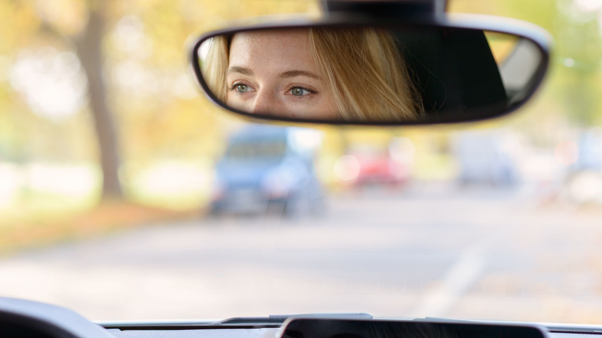 Водитель смотрит в зеркало. Глаза в зеркале машины.