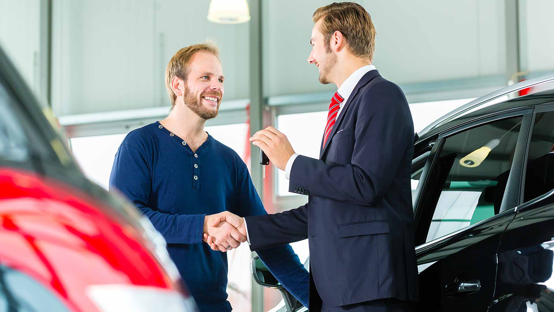 Young car buyer shaking hands on a deal
