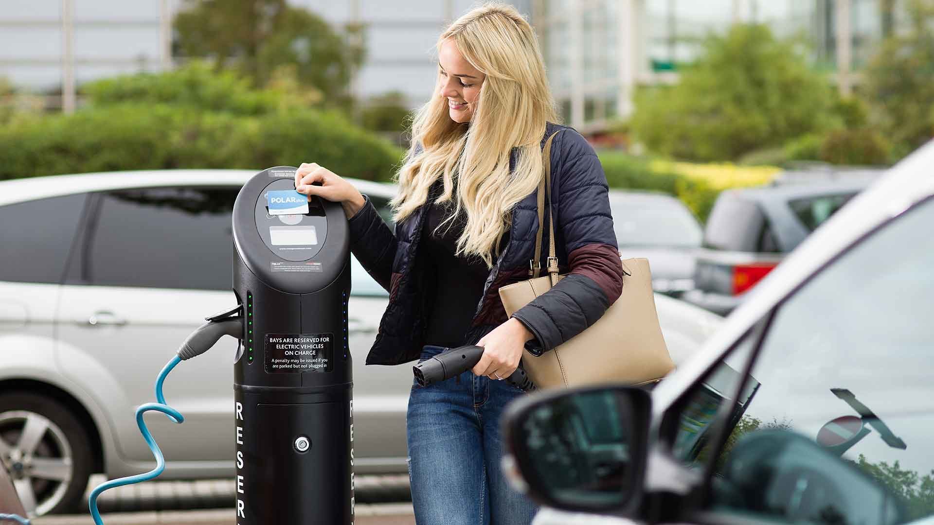 Young woman using a BP Chargemaster charging post