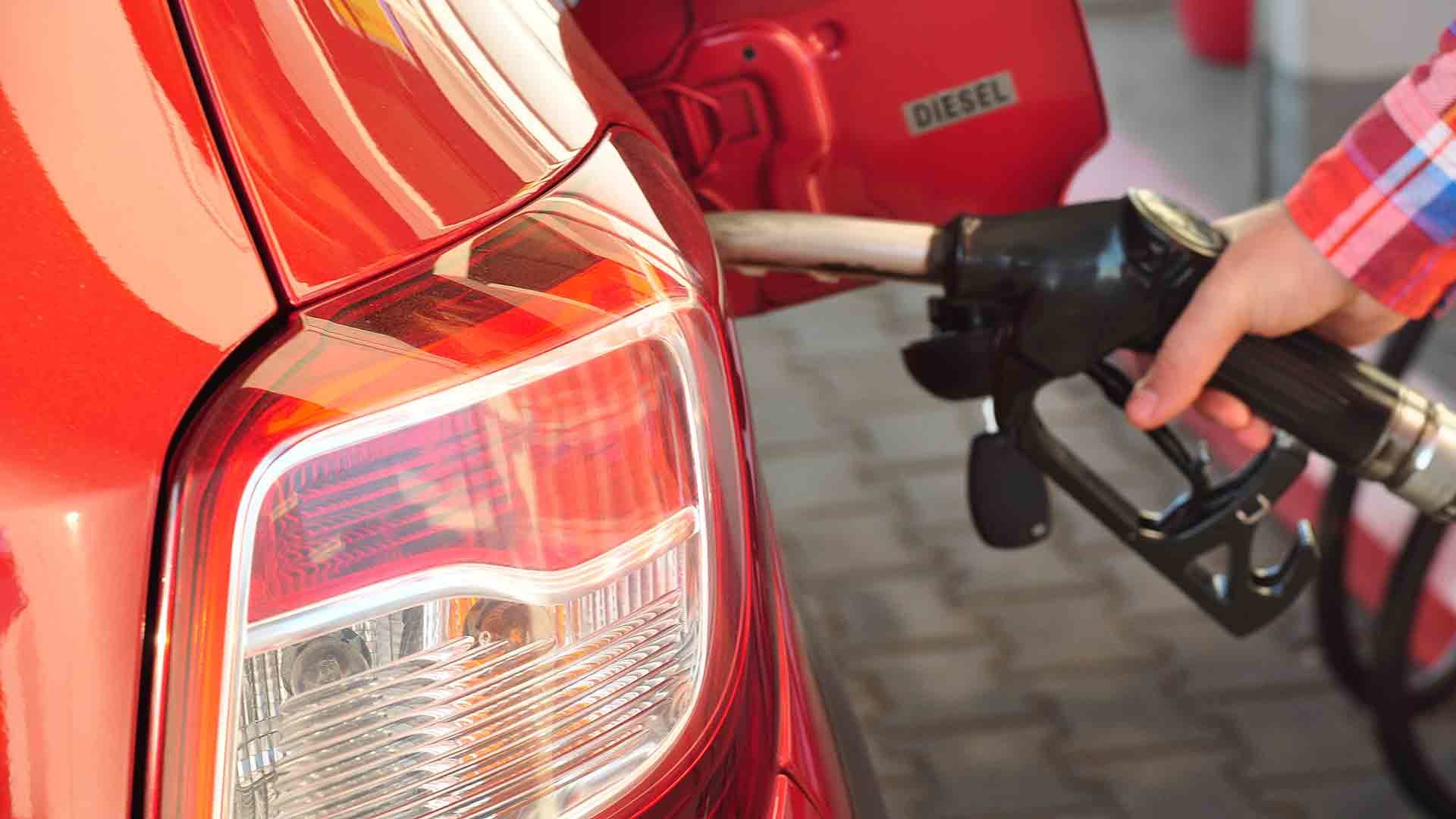 Person filling a diesel car with fuel