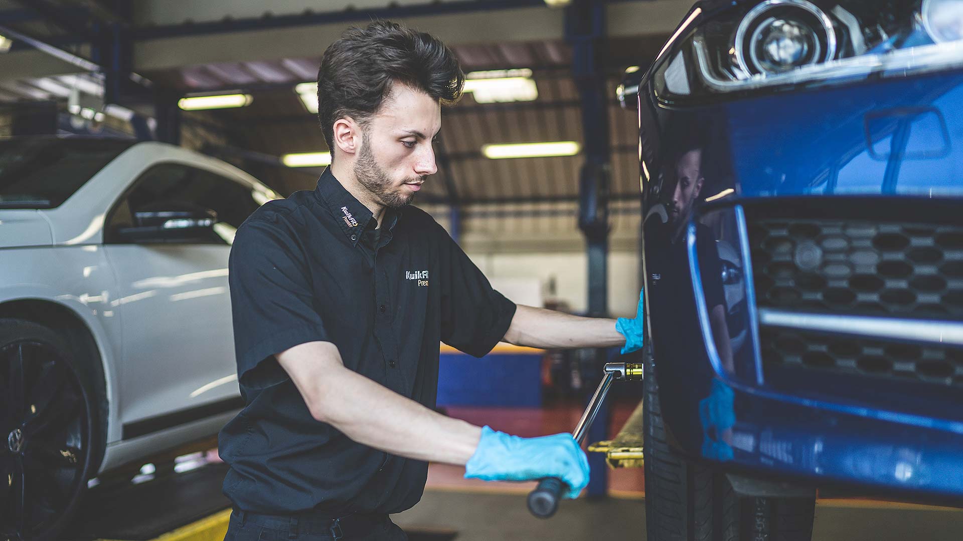 Kwik-Fit technician fitting a new tyre